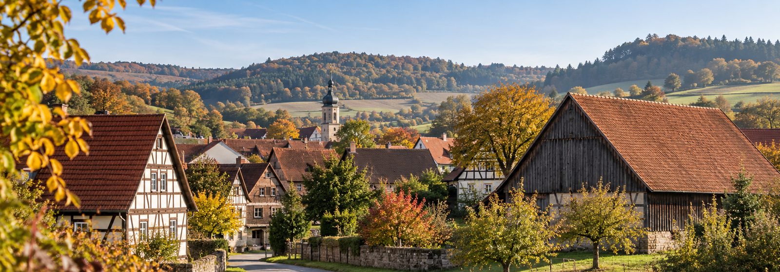 Fachwerkdorf im Hügelland mit großer Scheune im Herbst